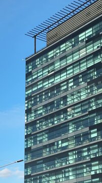 Modern Glass Facade Architecture in an Urban Environment That is Both Dynamic and Stylish. This stylish glass building exterior beautifully showcases cutting-edge modern architectural design.