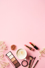 Woman flat lay on pink background. Eyeshadow, lipsticks and cup of coffee with easter eggs.