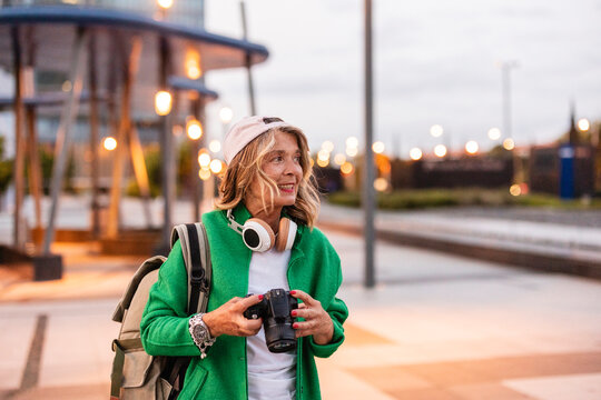 Tourist with camera and backpack sightseeing in urban outdoor setting