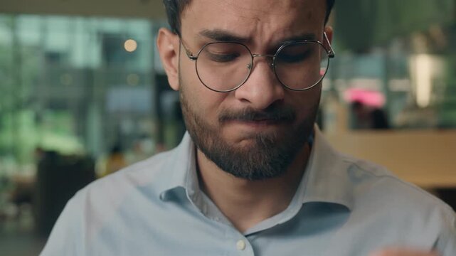 Angry Indian business man Arabian businessman irritated with broken headphones wired earphones problem annoyed Muslim guy male professional feeling stressed with headset difficulty furious emotion