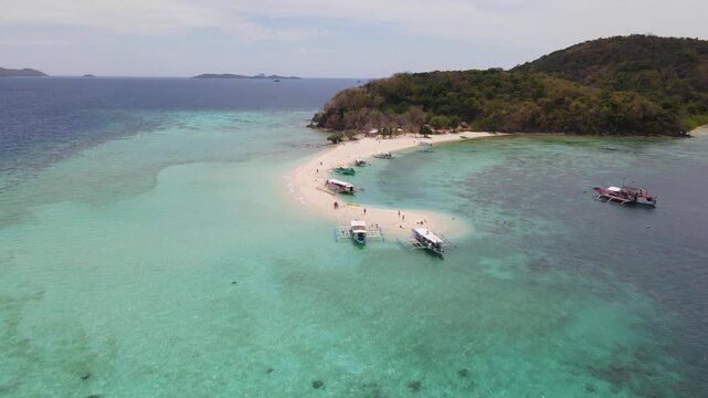 Aerial view of boats resting on the white sandbar surrounded by turquoise waters, a tropical paradise, Coron, Mimaropa, Philippines.