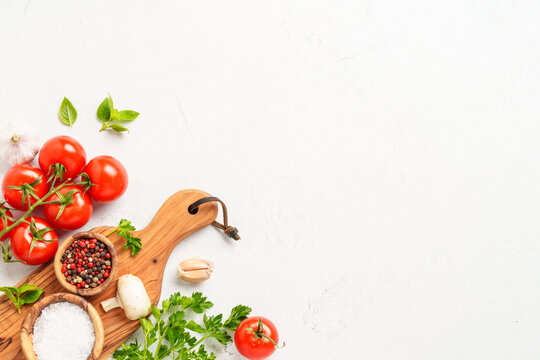 Spices, herbs and vegetables with olive oil on white kitchen table.
