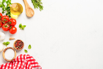 Spices, herbs and vegetables with olive oil on white kitchen table.