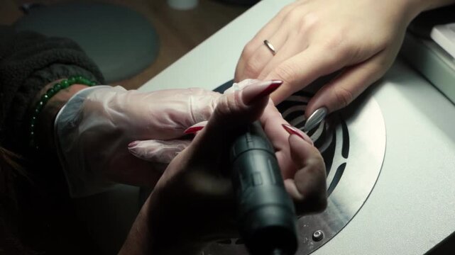 beauty master manicurist doing nails to a beautiful young girl in a beauty salon, female beauty and self-care, with her hands and fingers. Close up of handyman tools