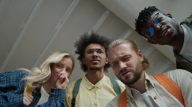 Close up portrait four diversity friends looking at camera grimacing faces bad terrible odor problem trouble smell multiethnic students ugly disgust reaction smelling in university college academy