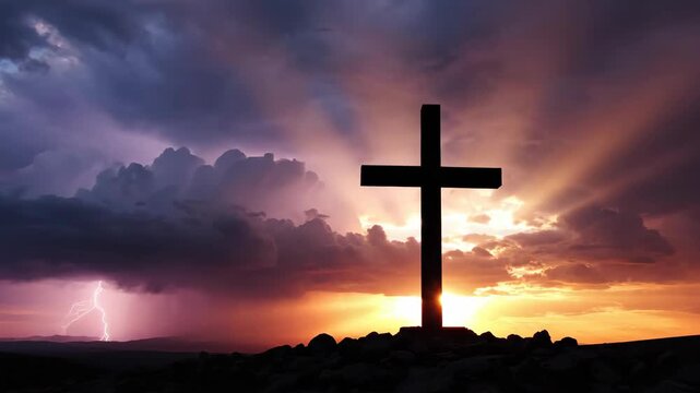 Silhouette of a Christian cross against a dramatic sunset with sun rays breaking through clouds