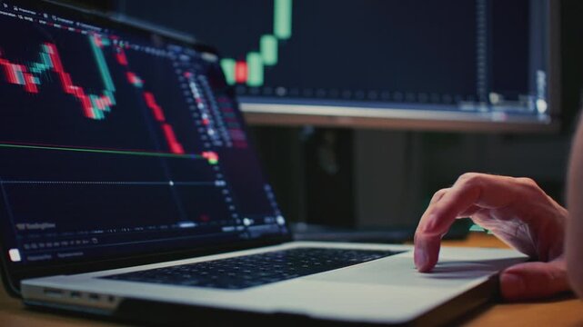 Close up: Investor laptop with a terminal, graphs and charts. Trader male hand makes stock purchases and investments in app. Cryptocurrency bitcoin, USD. Global market analysis online brokerage