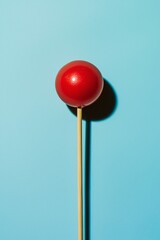 Red Round Candy on Stick Against Blue Background for Food Photography