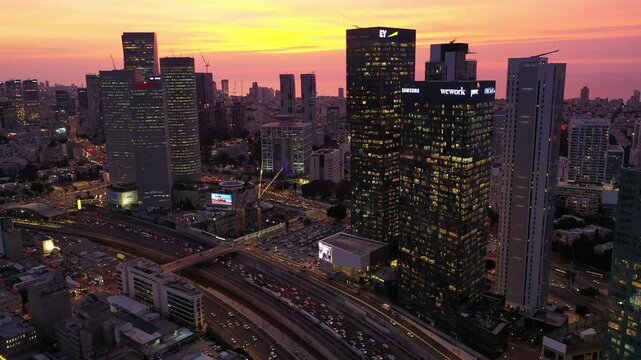 Aerial view of the Azrieli Center skyscrapers and the urban sprawl illuminated against the fading light of dusk, Tel Aviv-Yafo, Tel Aviv District, Israel.