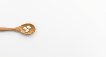 Obraz premium Wooden spoon holding white pills positioned on clean white surface with blank area for text
