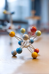 Molecular model on a wooden surface, a small desk toy that represents atoms and their bonds