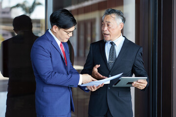 Businessmen talking about work and project in an office, discussing a document