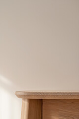 Fototapeta premium Empty white oak wooden tabletop and neutral beige plaster wall background with soft natural sunlight shadows, table mockup, podium stage for product placement, minimal home interior design template