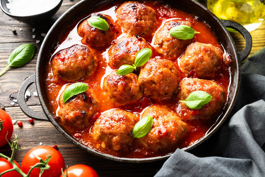 Meatballs in tomato sauce and basil. Traditional italian food. Close up image.