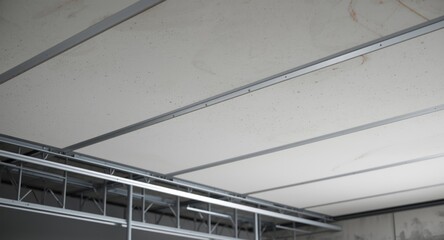 Fototapeta premium Suspended ceiling structure composed of drywall fixed by screws to metal frame copy space