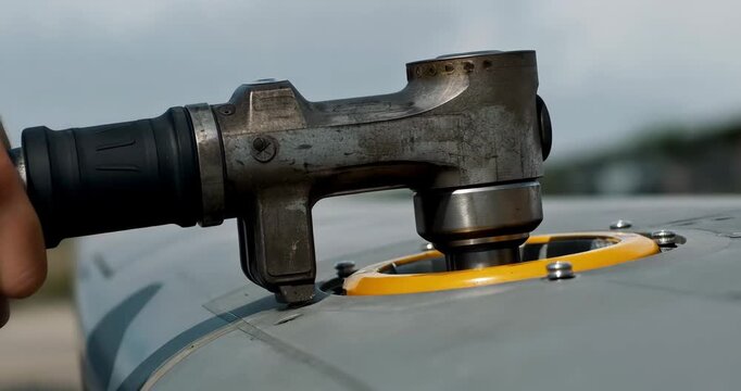 Airplane being refueled with fuel nozzle in airport tarmac