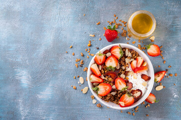 Healthy summer fruit breakfast bowl with granola, creamy greek yogurt and strawberry. Tasty...
