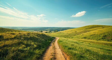 Fototapeta premium Rustic trail meandering through rolling hills with a bright blue sky overhead