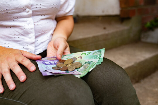 Close-up of a woman's hands holding New Zealand currency