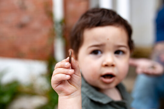 Young boy holding out a copper coin