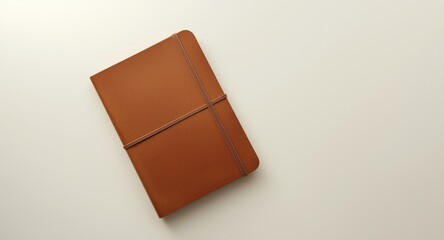 Top angle of a leather notebook mockup featuring elastic band on smooth white background and clipping path