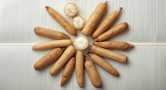 Top image of raw manioc rhizomes and yucca tubers arranged on white leaf surface for tapioca