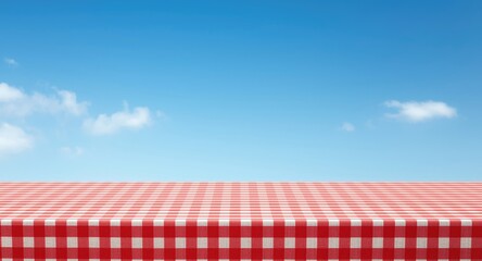empty cooking counter draped in red checkered fabric with open blue sky background for text