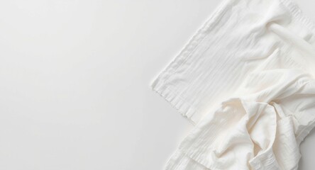 Obraz premium Bright white desk surface displaying a pile of linen dish towels shaped as napkins with copy space