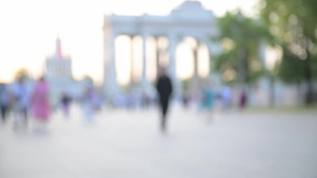 View of the city park and the square with people walking in the daytime in soft focus