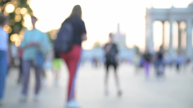 View of the city park and the square with people walking in the daytime in soft focus