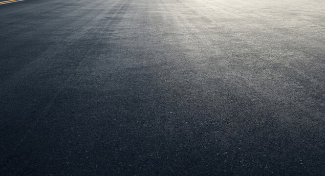matte asphalt racing surface backdrop under gentle shadow featuring copy space