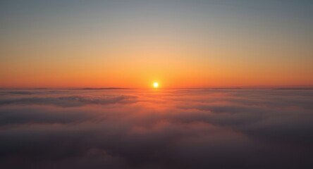 Sun rising at dawn illuminating endless foggy cloud landscape