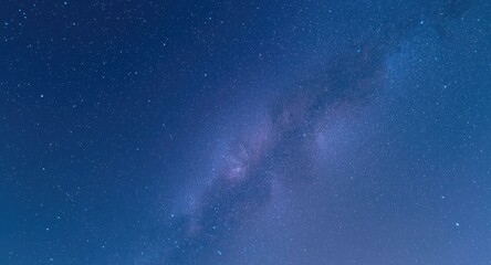 Fototapeta premium A peaceful blue sky above a luminous galaxy twinkling with star clusters