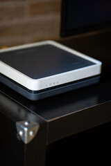 Modern internet router or modem device on a dark table, providing high-speed wireless connectivity and broadband network access for homes and offices