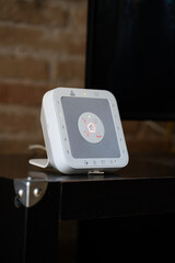 White smart home security hub displaying a central illuminated status light, integrating alarm system functions for modern house protection and automation