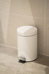 White pedal bin providing a practical solution for waste disposal in a clean, modern bathroom setting, emphasizing hygiene and tidiness in a home environment