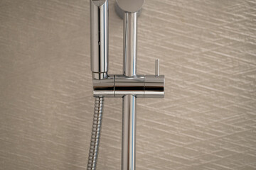 Modern chrome shower head and rail system for a contemporary bathroom, highlighting sleek metallic design and stylish plumbing fixtures