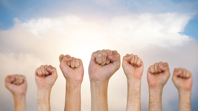 Labor Day celebration with hands raised in unity against a cloudy sky in the USA