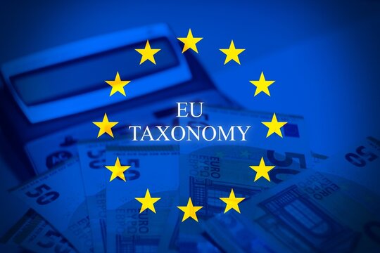 Stack of Euro banknotes with EU flag overlay and &ldquo;EU Taxonomy&rdquo; text. Represents European sustainable finance, ESG regulation, and responsible investment frameworks.