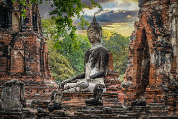 Obraz premium Ayutthaya, Thailand - Ancient Buddha statue among the destroyed statues in Ayutthaya historical park.