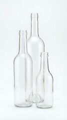 Three empty clear glass bottles of different sizes arranged together on white background for packaging design and beverage industry concepts.