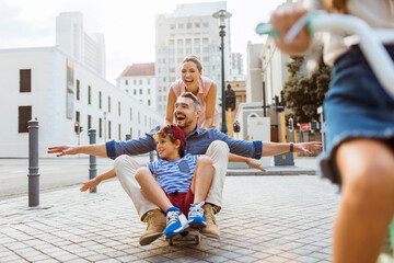 Parents and kids riding skateboard on city street © Geber86