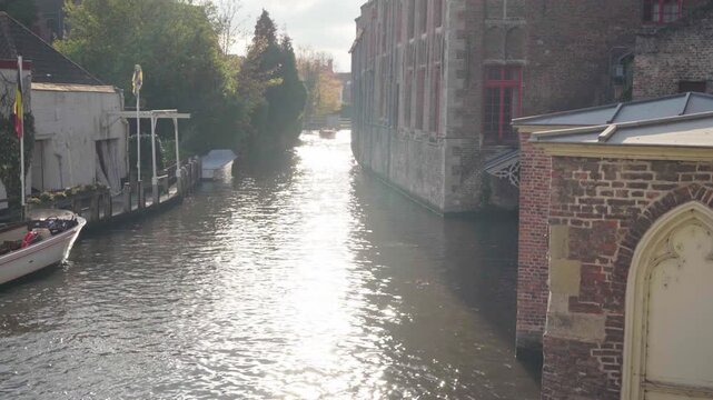 River reveal with reflections next to church in Bruges Belgium