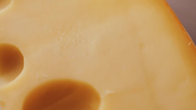 Bright yellow Emmental cheese or Maasdam cheese with large holes close up. High quality 4k footage