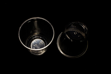 Clear plastic cup isolated on black background