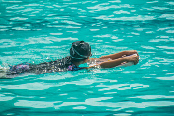 Asian child competing swimmer in the swimming pool swimming foam