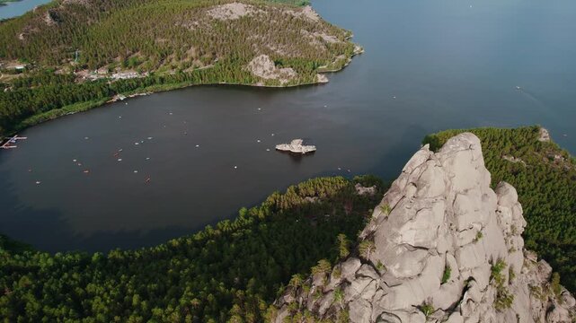 Beautiful landscape of tranquil lake with boat, forests and rocky mountains. Aerial view National nature park Burabay, Kazakhstan.