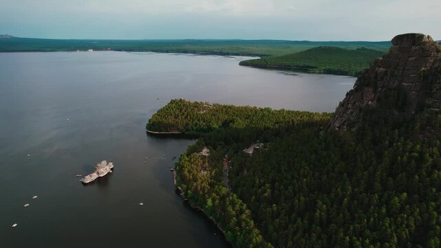 Beautiful landscape of tranquil lake with boat, forests and rocky mountains. Aerial view National nature park Burabay, Kazakhstan.