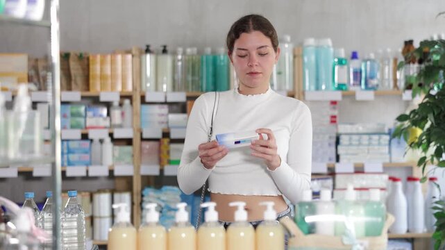 Female buyer buys medicinal ointment at a pharmacy. High quality 4k footage