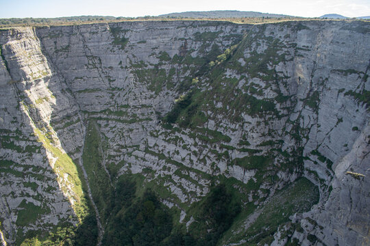 Vista de una gran formaci&oacute;n rocosa con una grieta central en una ladera cubierta de hierba en Burgos, Espa&ntilde;a